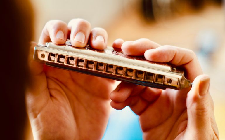 Close up of hands holding a harmonica