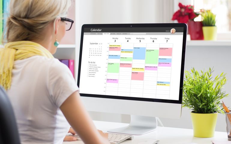 Woman using calendar app on computer in office