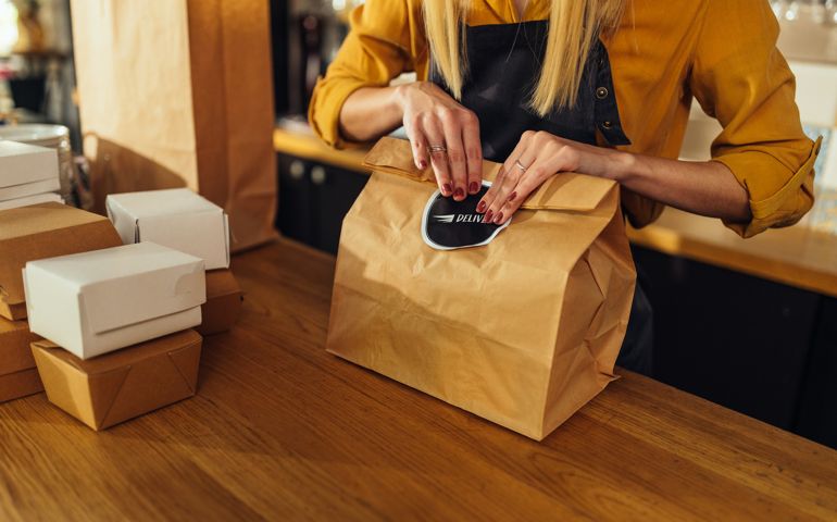 Close up of woman packing food for delivery