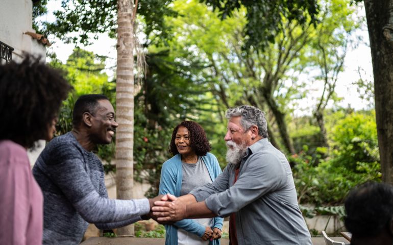 Neighbors greeting each other at front house
