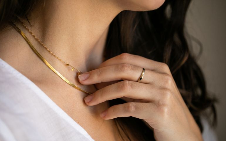womanwith ring holding necklace