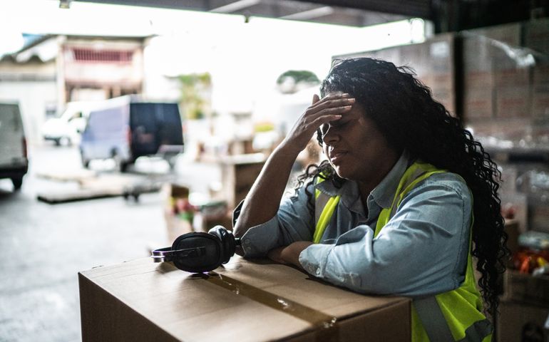 Tired or worried female warehouse worker