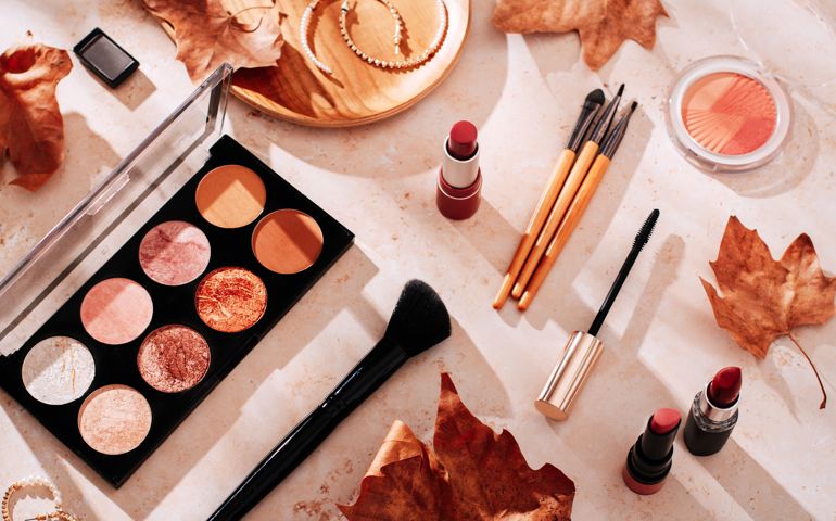 Autumn skincare and autumn makeup concept with beauty products on table