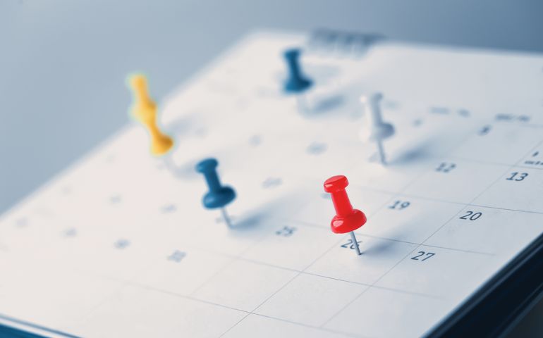 Embroidered red pins on a calendar event Planner calendar,clock to set timetable organize schedule,planning for business meeting or travel planning concept.