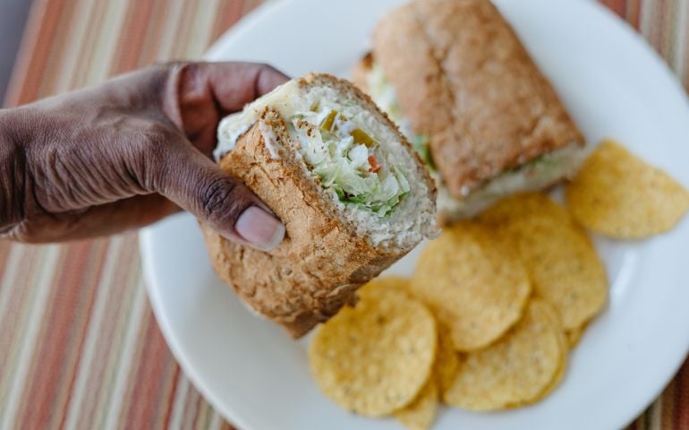 Woman Eats Tuna Salad Sandwich and Tortilla Chips