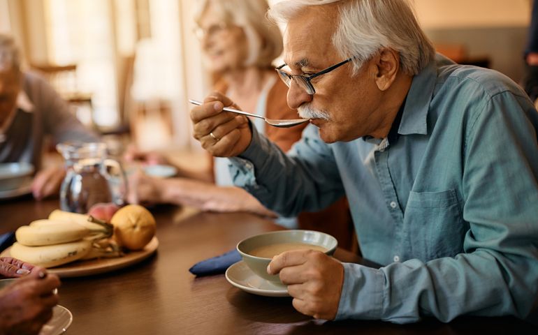 Senior man eating lunch at nursing home.