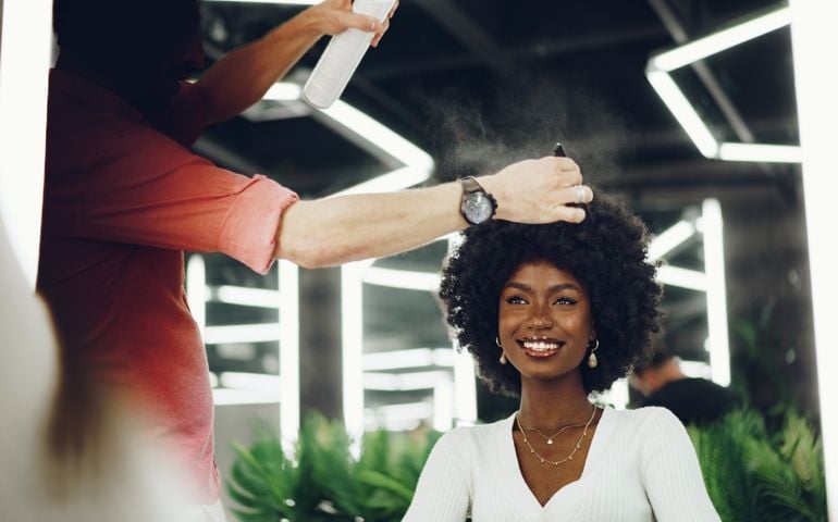 Young african woman customer getting a hairstyle at a beauty salon.