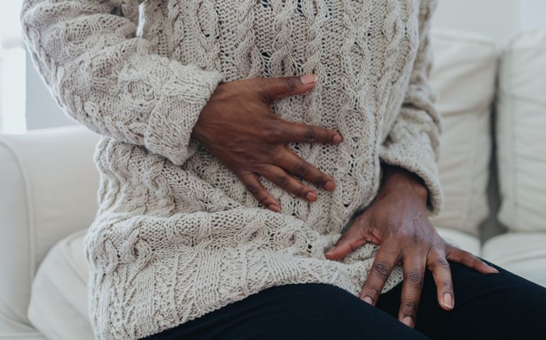 Woman Holds Abdomen in Pain