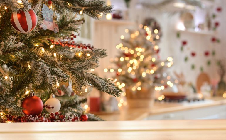 Empty wooden table on the background of christmas tree and blurred christmas kitchen, golden bokeh.Christmas background. Merry Christmas and Happy New Year! Ready for product montage.Mockup.
