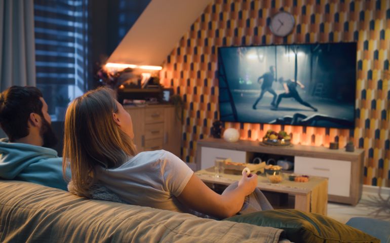 Couple watching action movie on TV at home