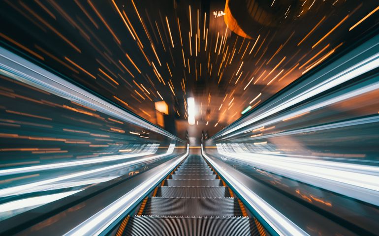 Empty escalator in illuminated tunnel with fast motion