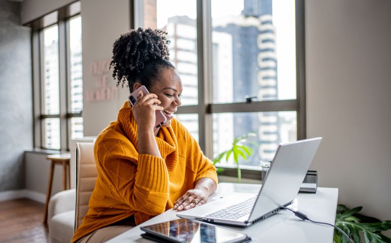 Black woman talking on the phone at home
