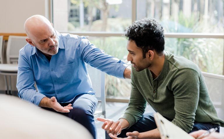 Mature man helps younger man verbalize problems in therapy
