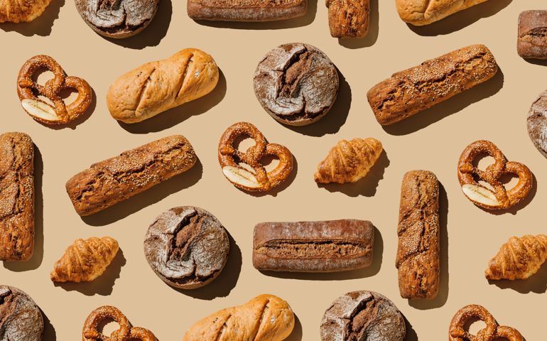 Pattern of various bakery products handmade on beige background. Creative layout with bread, buns, croissant, bread loaves and pretzels. Modern minimal food photography collage in pop-art style. Flat lay, top view
