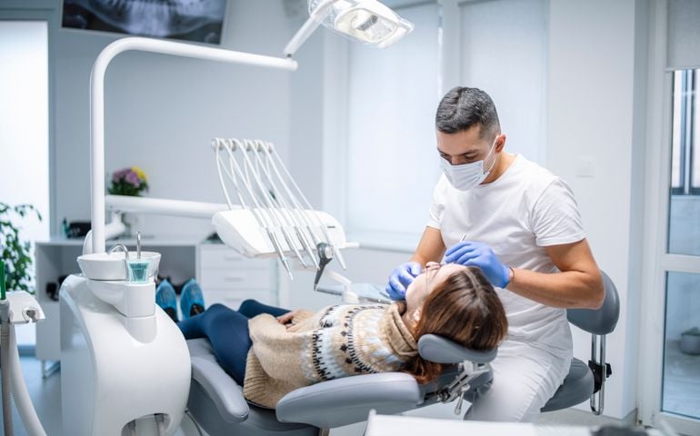 Dentist examining female patient.