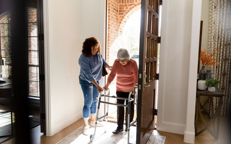 Mid adult woman helps her senior adult friend