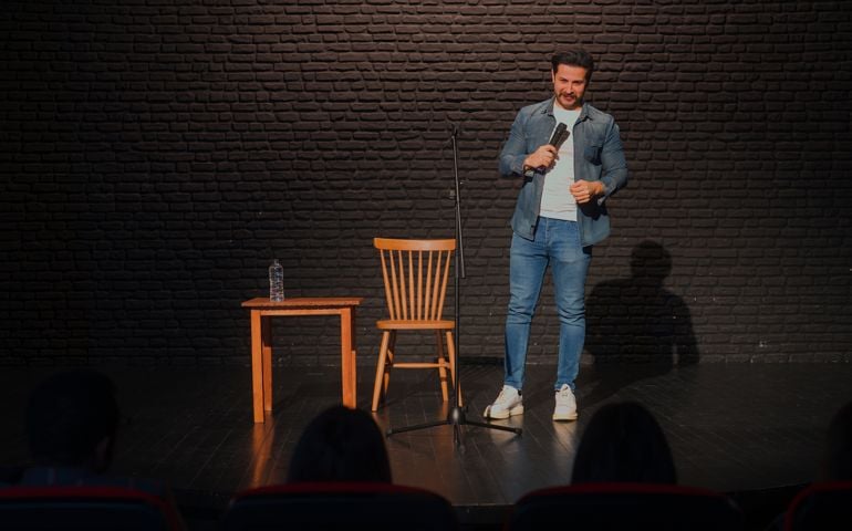 Male stand-up comedian talking on stage