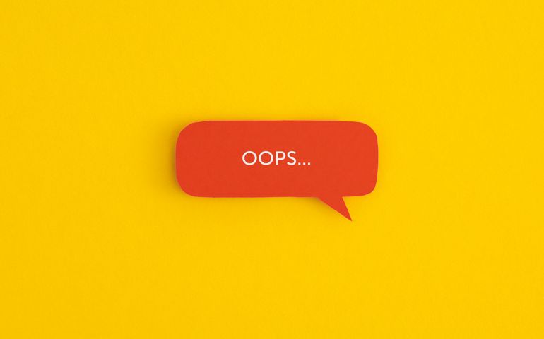 Paper speech bubble with the word "OOPS" on a yellow background. Top view with copy space. Flat lay.