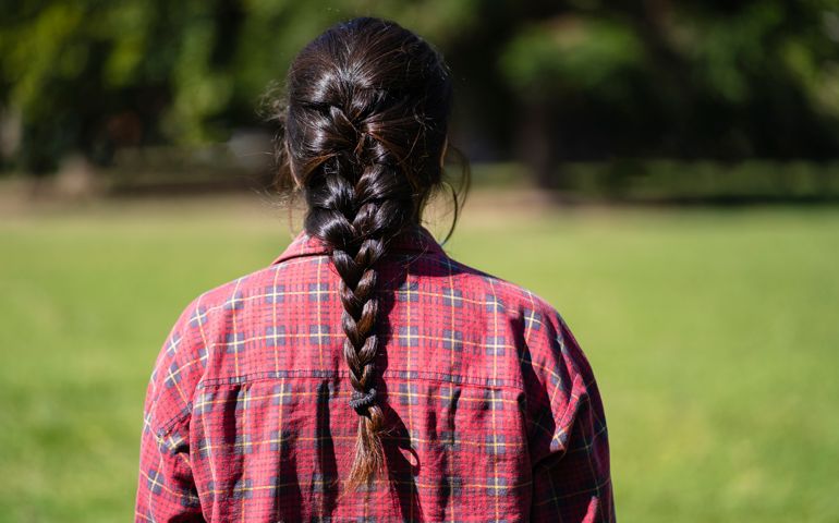 Latin woman from behind wearing a braid in a park