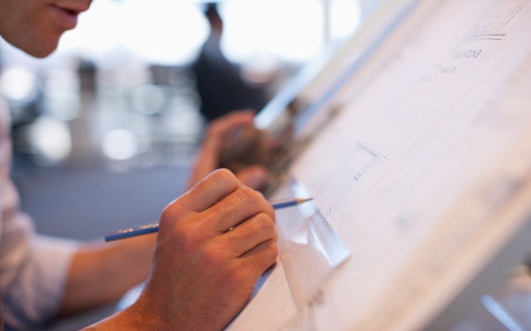 Businessman drawing on drafting table in office