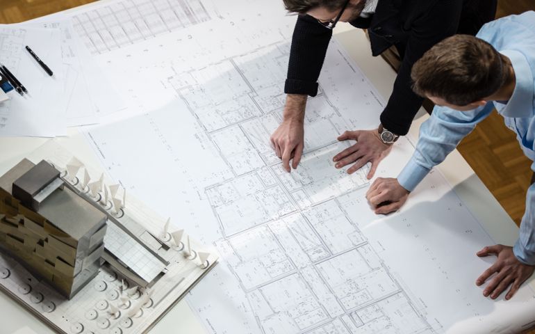 Architect explaining blueprint to client