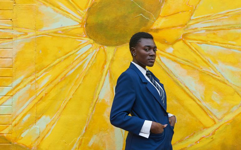 Serious androgynous Black woman standing near mural