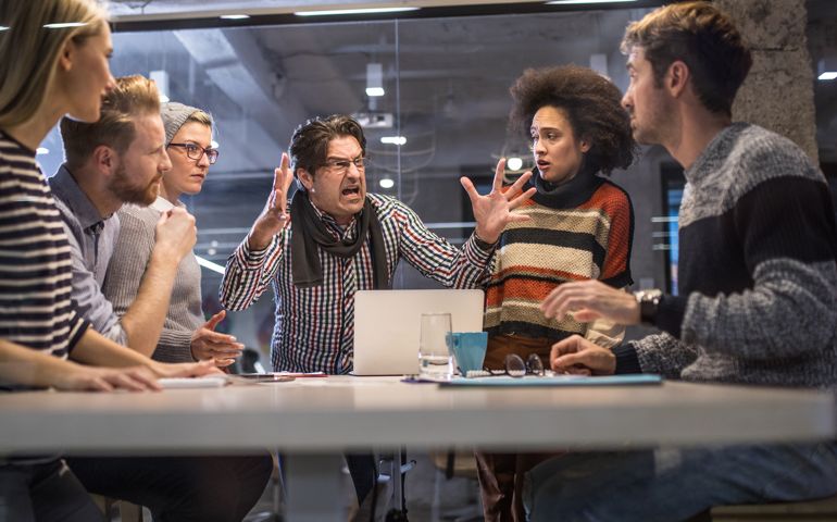 Furious boss shouting at his team on a meeting in the office.