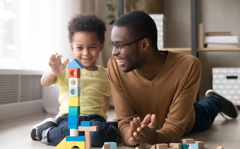 happy child with block beside father