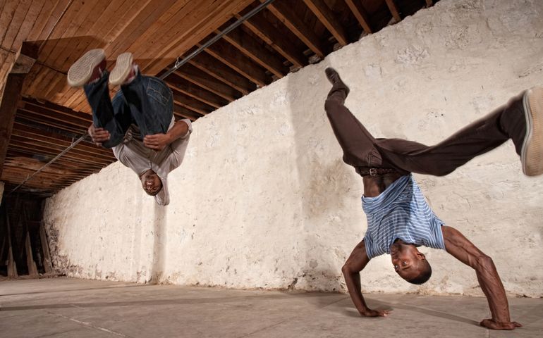 Two acrobatic capoeria artists do headstands and backflips