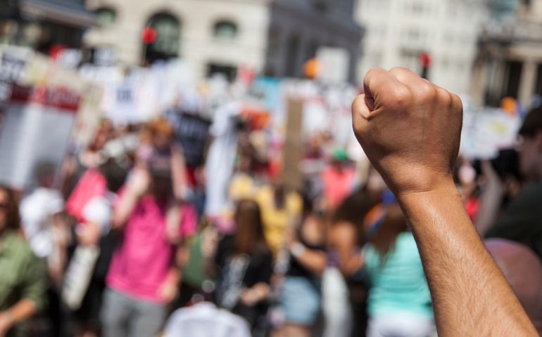 A raised fist of a protestor at a political demonstration