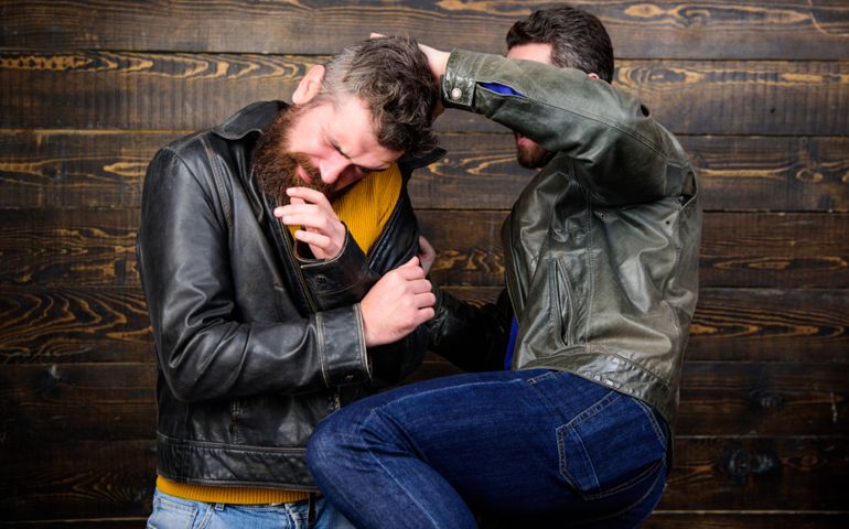 Street fight concept. Men brutal hooligans wear leather jackets fighting. Physical attack. Men bearded hipster fighting. Attack and defence. Aggressive hooligan fighting with strong bully man.