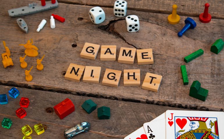 British Columbia, Canada, - February 01, 2019 - "Game Night" made from Scrabble game letters, Risk, Battleship pieces, Monopoly, Settler of Catan and other game pieces
