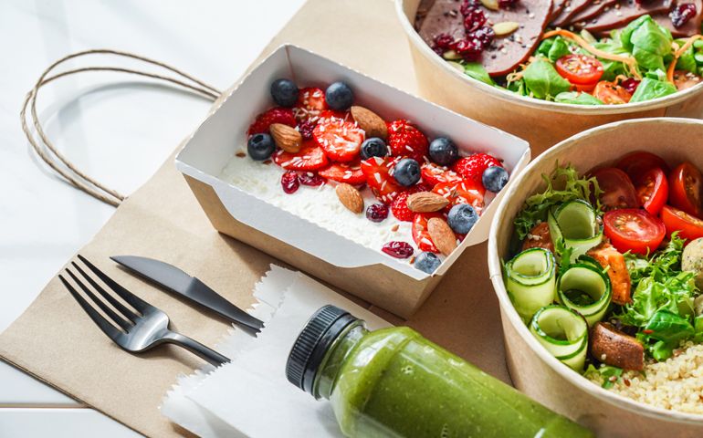 Healthy meal slimming diet plan daily ready menu background, organic fresh dishes and smoothie, fork knife on paper eco bag as food delivery courier service at home in office concept, close up view