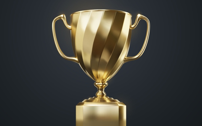 Golden champion cup isolated on black background.