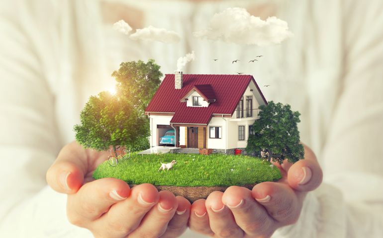 Small fantastic island with a house and backyard in women's hands.