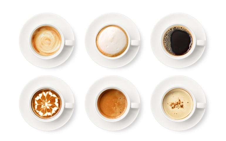 Flay lay of coffee cup assortment isolated on white background.