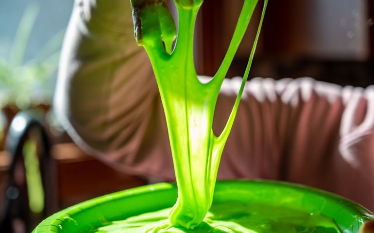 focus on slime covered hands with strings of gooey webbing down