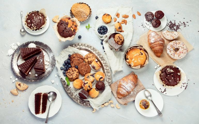 Dessert table with all kinds snacks on light background. Candy bar. Celebration concept. Top view, flat lay