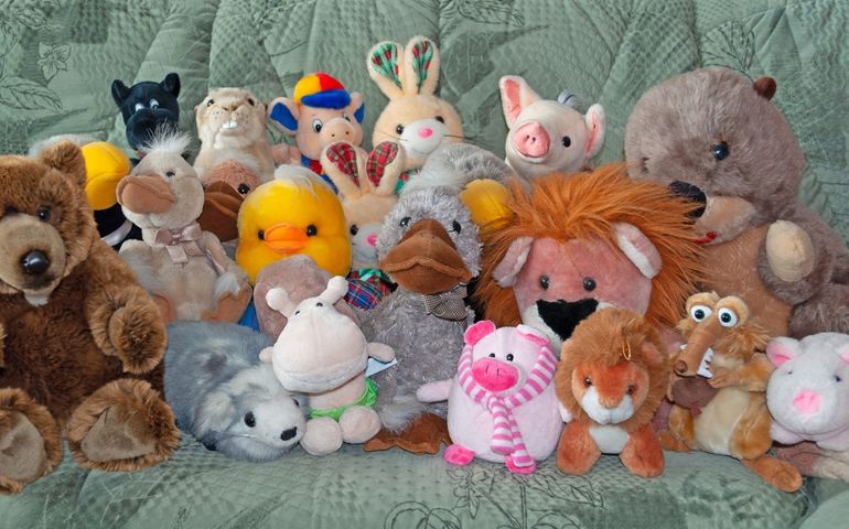 Lots of stuffed animals on a sofa