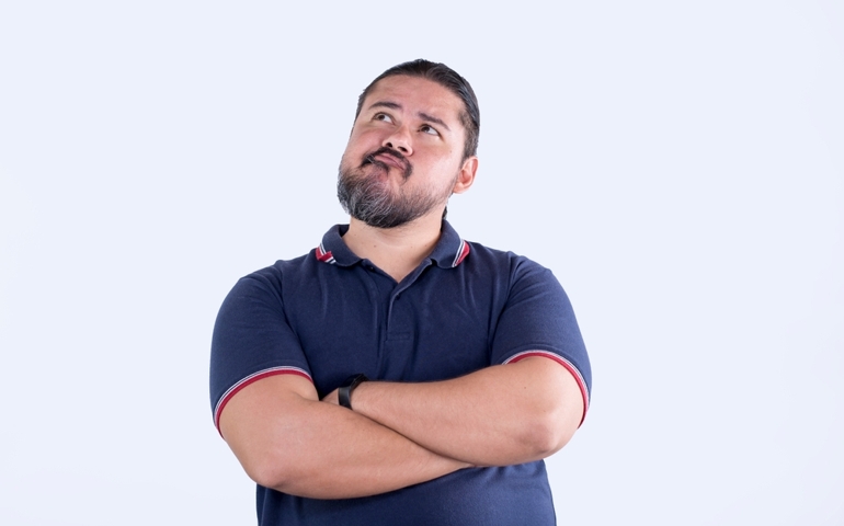 A man pondering about his options, looking up to his right. Slightly exaggerated and comical facial expression. Isolated on a white background.