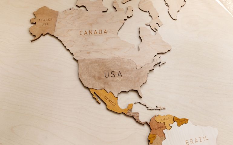 Wooden map of the world on a light background. Self made. Plywood. In beige tones. North and Latin America. Geography. USA, Canada, Alaska, Mexico, Brazil, Cuba, Venezuela.