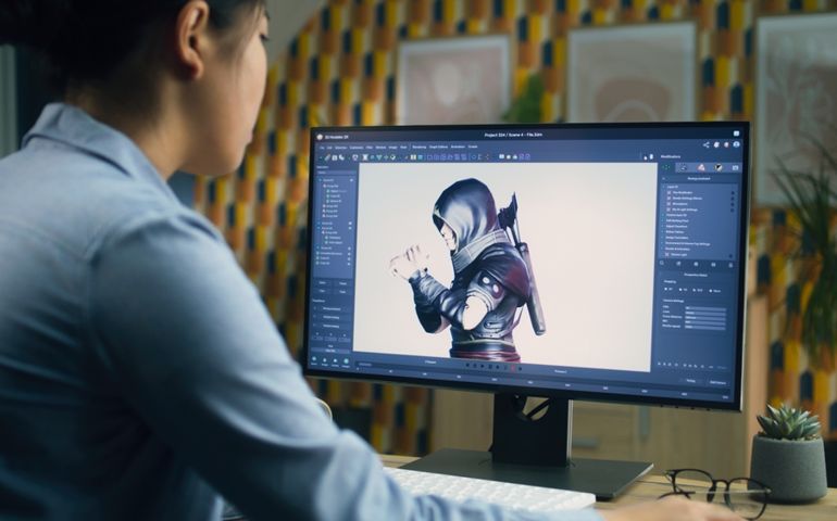 Female 3D designer creating and drawing character for video game using computer while sitting at the table at home office and doing distant work. 3D modeling