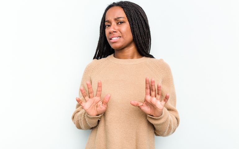 Young African American woman isolated on white background rejecting someone showing a gesture of disgust.