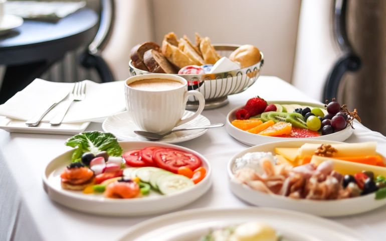 Luxury hotel and five star room service, various food platters, bread and coffee as in-room breakfast for travel and hospitality brand