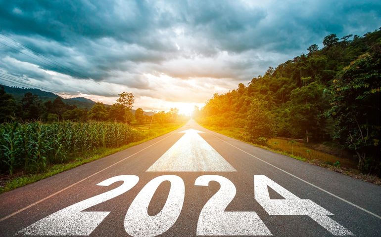 New year 2024 or straight forward concept. Text 2024 written on the road in the middle of asphalt road with at sunset.