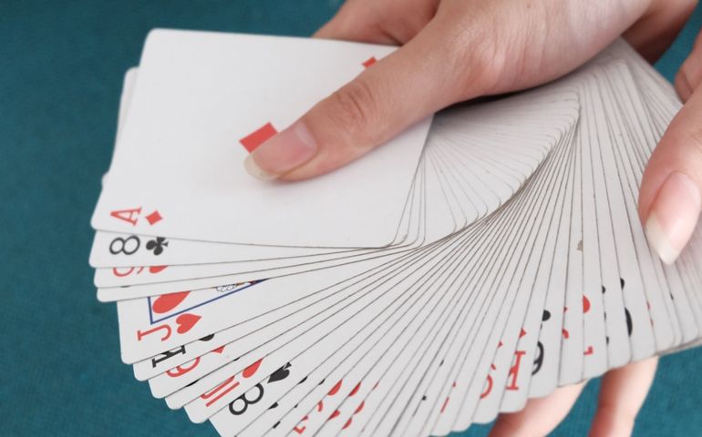 Hand playing blue deck card