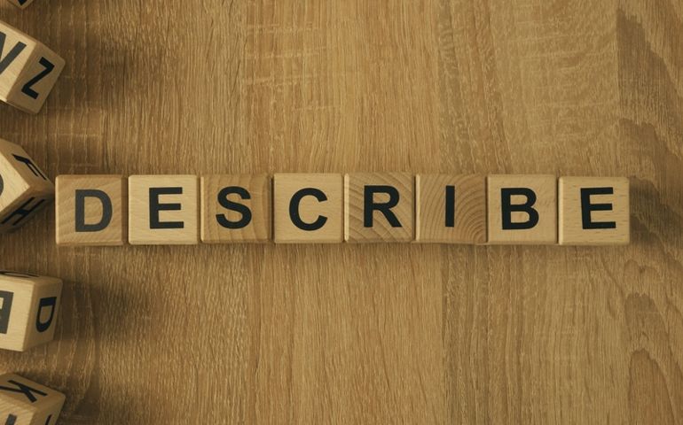 Describe word made with building blocks. Wooden Blocks with the text: Describe. The text is written in black letters.