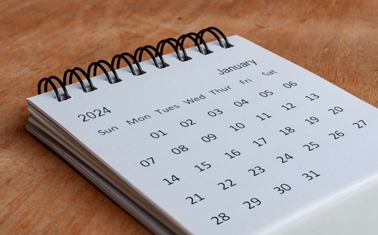 January 2024 white table calendar on wooden background. Calendar concept.
