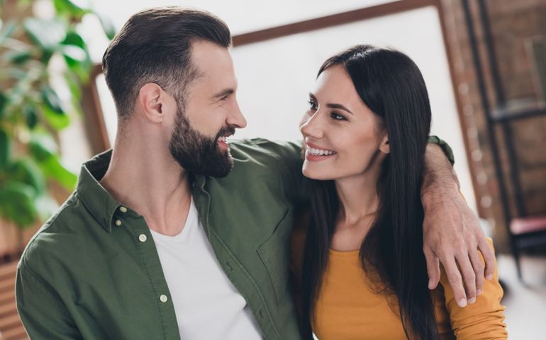 Portrait of attractive sweet cheerful couple hugging spending spare time staying safe at home house flat indoors