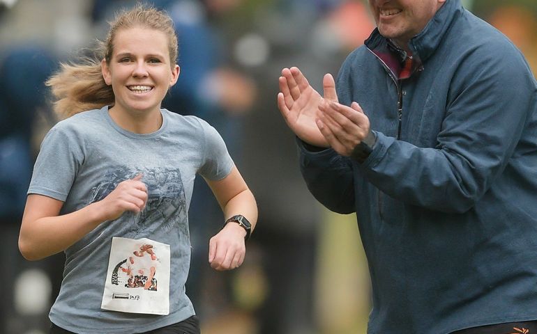 man cheering on woman as she runs